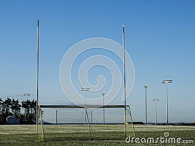 Irish sport training ground with tall goal posts for camogie, Gaelic football and rugby on a cold winter day. Frost on the green Stock Photo