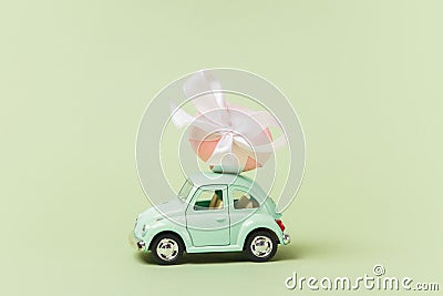Irkutsk, Russia - january 17, 2021: Light green retro toy car carries easter egg. Minimal easter concept Editorial Stock Photo