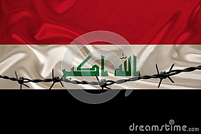 Iron barbed wire against the background of the national silk flag of the state of Iraq, the concept of imprisonment for offenders Stock Photo