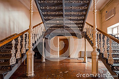 Iron beautiful vintage stairs in the old mansion. Ornate handrail of wrought iron Stock Photo