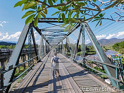 A tourist takes a photo on the old Ta Pai Memorial Bridge Editorial Stock Photo