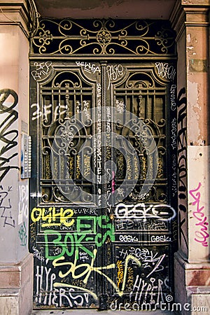 Iron door painted black with graffiti and wrought iron Editorial Stock Photo