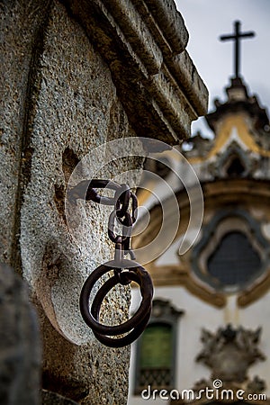 Iron handcuffs used to torture slaves in front of a church Stock Photo