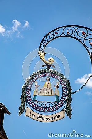 iron historic symbol and signage of a patisserie with figures of the pattiseur and a big cake Editorial Stock Photo