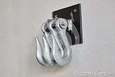 Iron hooks on white concrete wall Stock Photo