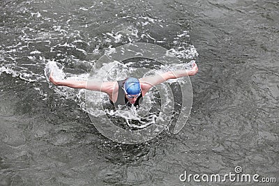 Iron man - swimmer performing the butterfly stroke in dark ocean water Stock Photo