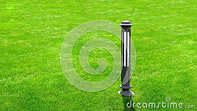 Iron outdoor garden lighting lantern on a green meadow lawn. Stock Photo