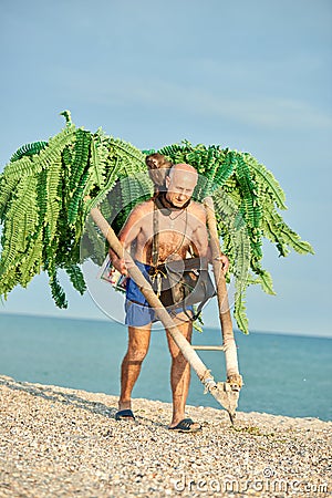 IRON PORT, KHERSON REGION, UKRAINE 06/08/2019 MAN PHOTOGRAPHER ON THE BEACH, MAKES PHOTOS WITH A MONKEY Editorial Stock Photo