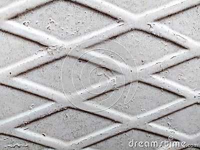 Iron white fence with rhombs, peeling paint, and under it rust. Abstract background Stock Photo