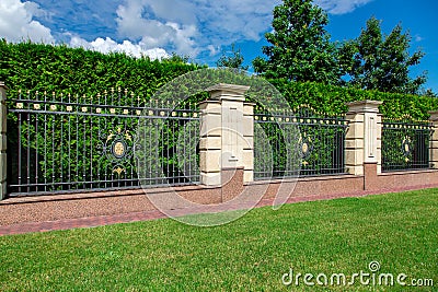 An iron wrought fence with capital stone columns. Stock Photo