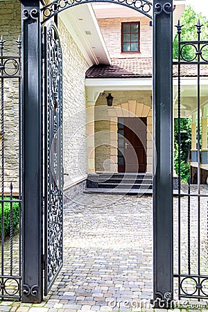 Iron wrought iron gate entrance to the back yard. Stock Photo