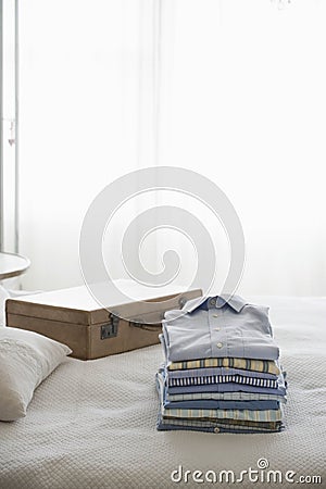 Ironed And Folded Shirts On Bed Stock Photo