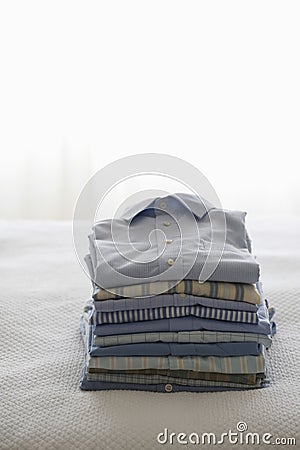 Ironed And Folded Shirts On Bed Stock Photo