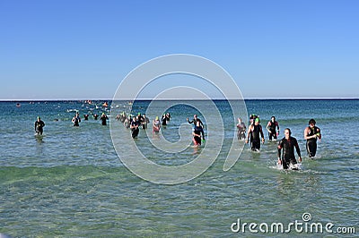 Ironman competitors exit ocean in Panama City Beach, Florida. Editorial Stock Photo