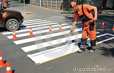IRPIN, UKRAINE - MAY 06, 2017: Worker is painting a pedestrian crosswalk. Technical road man worker painting and remarking pedestr Editorial Stock Photo