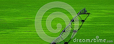 Irrigation Pivot in Lush Green Field with Circle Tracks on Ground Stock Photo