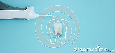 Irrigator near tooth model with protective vortex on blue background, professional clean teeth, teeth will good healthy Stock Photo