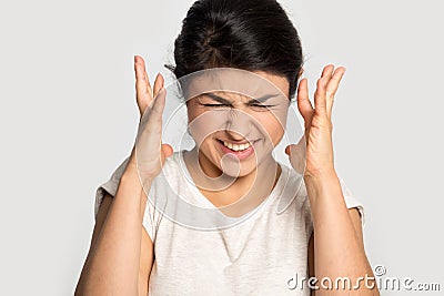 Irritated stressed millennial indian woman can`t stand noise. Stock Photo