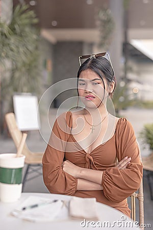 An irritated woman crosses her arms as she is disgusted with the news she just heard Stock Photo