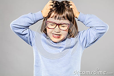 Irritated young girl pulling out hair for itchy lice allergies Stock Photo