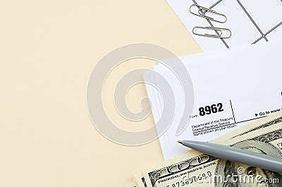 IRS Form 8962 Premium tax cerdit PTC blank lies with pen and many hundred dollar bills on calendar page Editorial Stock Photo