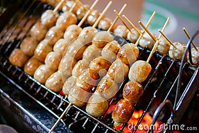 Isaan sausage being grilled on the traditional stove that be a part of street food in Thailand Stock Photo