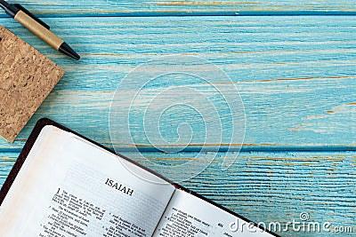 Isaiah open Holy Bible Book on a rustic wooden background with a notebook and pen Stock Photo