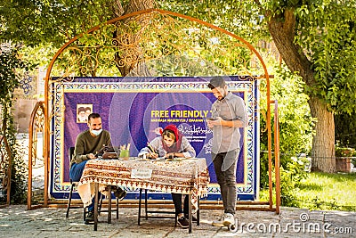 Isfahan, Iran - iranians sit learn symbols to write in Farsi language display corner in Isfahan Jame mosque courtyard Editorial Stock Photo