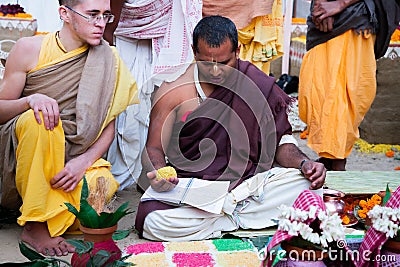 ISKCON Mayapur, West Bengal, India - Feb 15, 2020. young Hindu brahmana Vaishnav conducts ritual ceremony. Yagya fire flame ritual Editorial Stock Photo