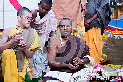 ISKCON Mayapur, West Bengal, India - Feb 15, 2020. young Hindu brahmana Vaishnav conducts ritual ceremony. Yagya fire flame ritual Editorial Stock Photo