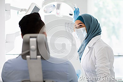 Islamic Dentist Doctor Lady Having Check Up With Male Patient In Clinic Stock Photo