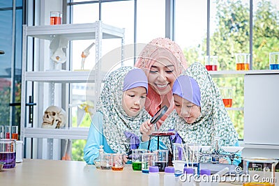 Islamic female teacher teaches science to girls in the classroom Stock Photo