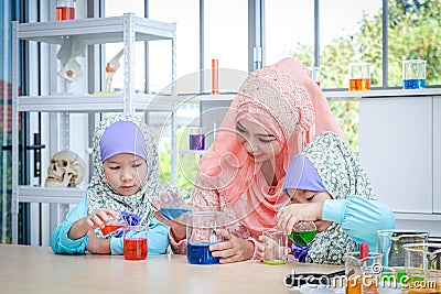 Islamic female teacher teaches science to girls in the classroom Stock Photo