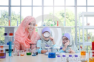 Islamic female teacher teaches science to two girls Stock Photo