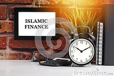 ISLAMIC FINANCE text with alarm clock, books and vase on brick background Stock Photo