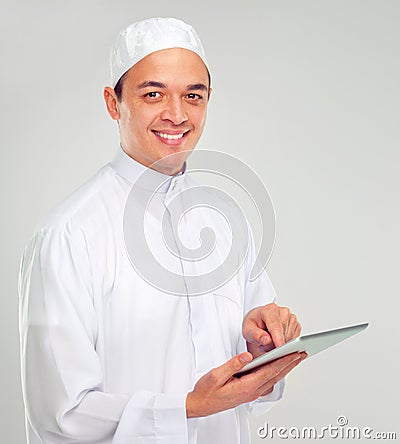 Islamic man, tablet and happy portrait for Muslim reading, education or culture standing in white background. Young Stock Photo