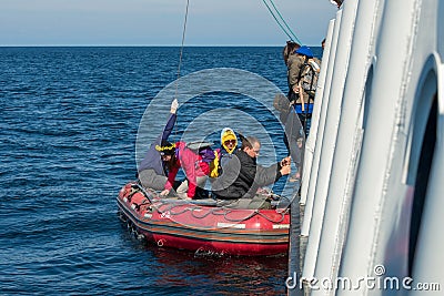 Boarding tourists from the ship in an inflatable boat Editorial Stock Photo