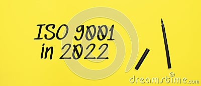 ISO 9001 in 2022 sign with black marker on a yellow background. With copy space ready for your text Stock Photo
