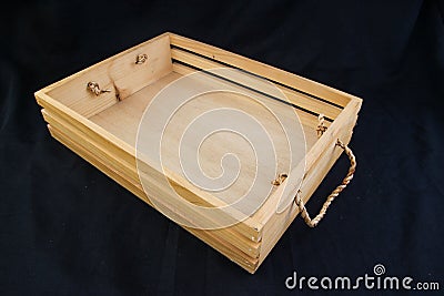 Isolate wooden box with rope grip handle on black background. Stock Photo