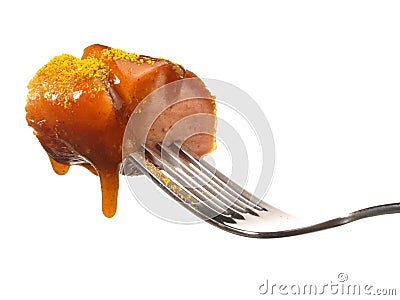 Isolated Curry Sausage on a Fork with Sauce Stock Photo