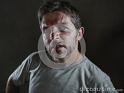 Isolated dark background portrait of young upset and defiant man in arrogant and cocky pose looking with contempt and inquisitive Stock Photo