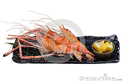 Isolated Grilled shrimps Giant Tiger Pawn with salt served with sliced lemon in black stone plate Stock Photo