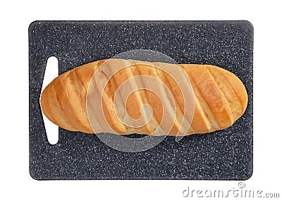 Isolated loaf of bread on grey rectangular cutting board on white background. Stock Photo