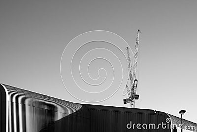 Isolated pair of large construction cranes seen against a clear, winter sky. Editorial Stock Photo