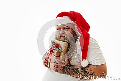 Isolated portrait on a white background of an overweigh man in Santa Claus hat expressing emotions greed and hugging a Stock Photo