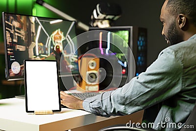 Isolated screen tablet next to man playing SF videogame on computer Stock Photo
