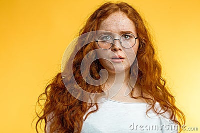 Isolated shot of young funny redhead female stares at camera with shoked expression Stock Photo