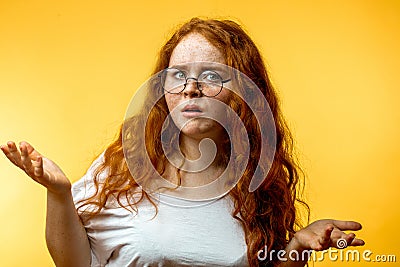 Isolated shot of young funny redhead female stares at camera with shoked expression Stock Photo