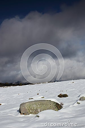 Isolated stone in a snowy landscape in Pyrenees Stock Photo