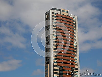 Isolated tall apartment building over a cloudy blue sky copy space Stock Photo